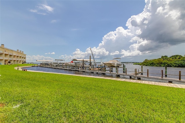 view of dock with a lawn and a water view