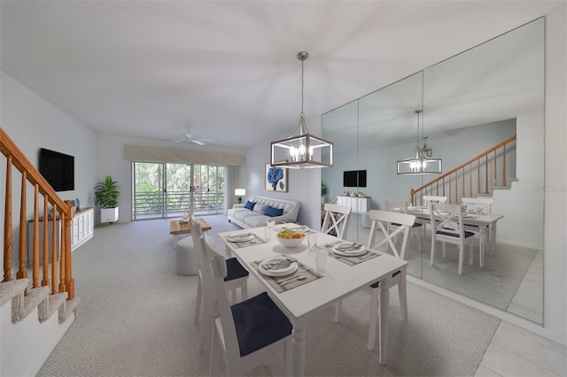 dining space featuring ceiling fan with notable chandelier and light colored carpet