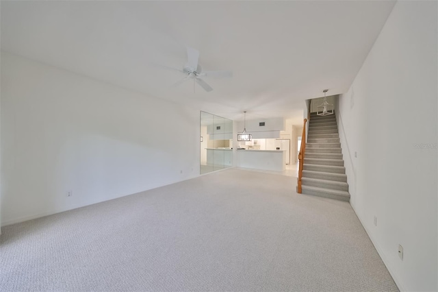 unfurnished living room featuring ceiling fan and light colored carpet