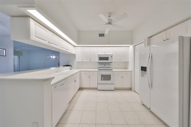 kitchen featuring white appliances, white cabinets, light tile patterned floors, sink, and kitchen peninsula