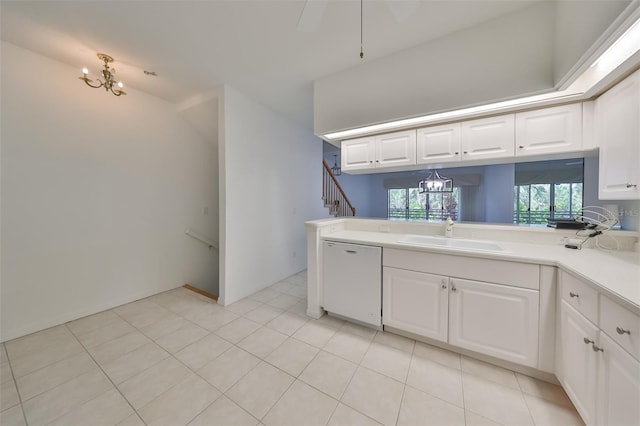 kitchen with white dishwasher, kitchen peninsula, white cabinets, light tile patterned flooring, and sink