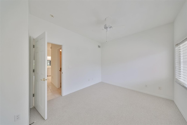 carpeted spare room with ceiling fan