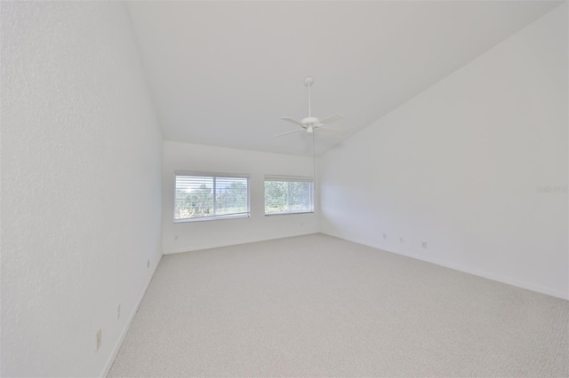 empty room featuring vaulted ceiling, ceiling fan, and carpet flooring