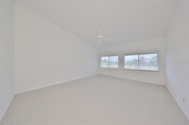 carpeted spare room with ceiling fan and lofted ceiling