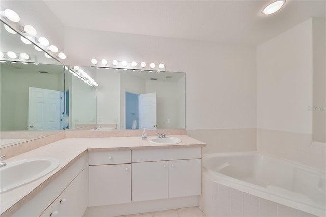 bathroom with tile patterned floors, double sink vanity, and a relaxing tiled tub