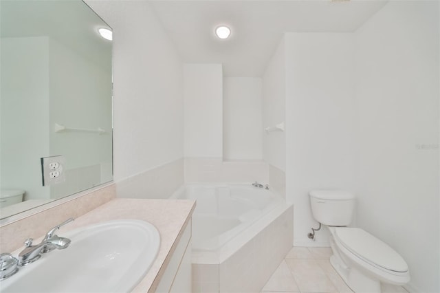 bathroom with tiled tub, tile patterned floors, vanity, and toilet