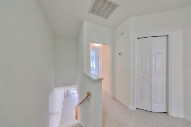 hallway featuring light colored carpet