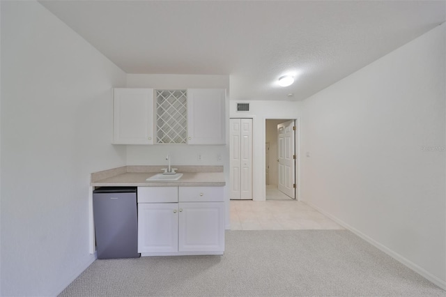 kitchen with light colored carpet, sink, dishwasher, and white cabinetry