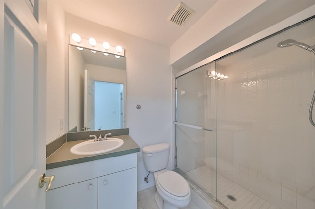 bathroom featuring vanity, a shower with shower door, and toilet