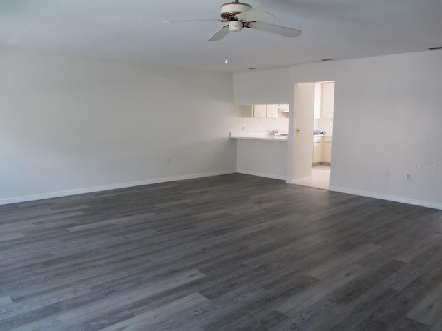 unfurnished living room with ceiling fan and dark hardwood / wood-style flooring