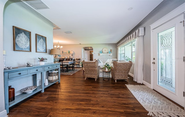 entryway featuring dark wood-type flooring and an inviting chandelier