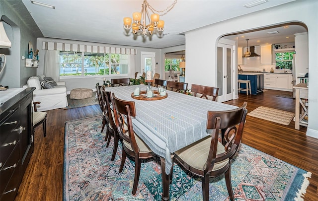 dining room featuring dark wood-type flooring and an inviting chandelier