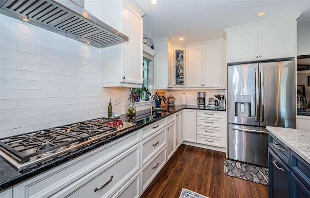 kitchen with dark hardwood / wood-style flooring, premium range hood, stainless steel appliances, dark stone countertops, and white cabinets