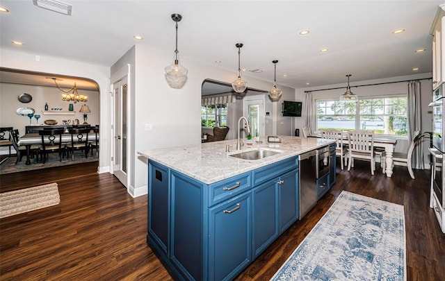 kitchen featuring dark hardwood / wood-style flooring, an island with sink, sink, light stone countertops, and blue cabinets