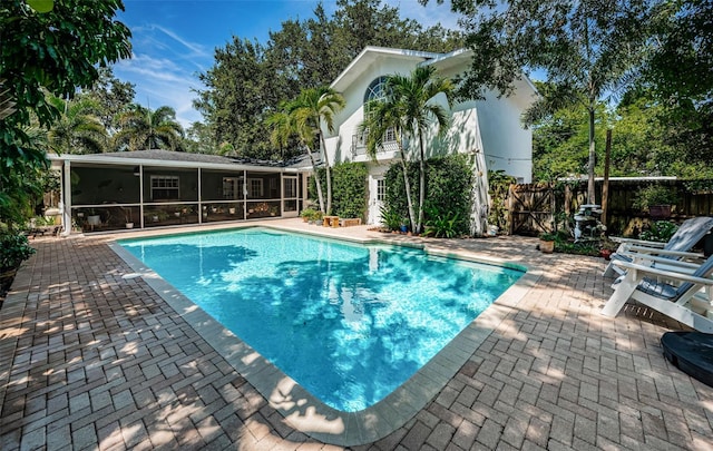 view of swimming pool with a patio and a sunroom