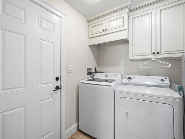 clothes washing area featuring cabinets and independent washer and dryer