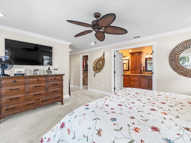 carpeted bedroom with ensuite bath, ornamental molding, a walk in closet, and ceiling fan