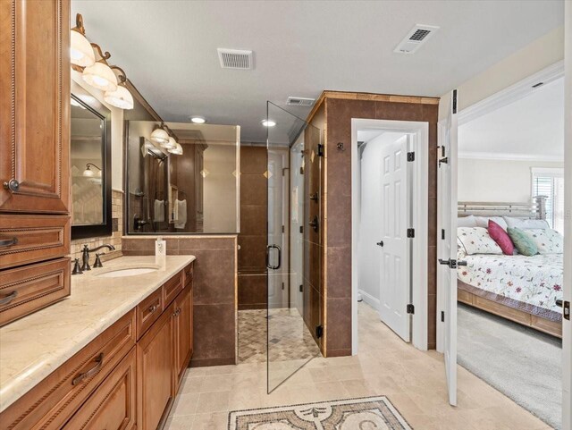 bathroom featuring crown molding, vanity, an enclosed shower, and tile patterned flooring