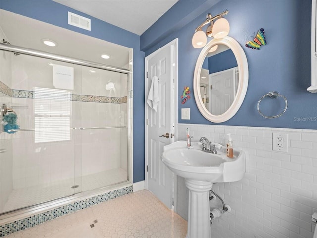 bathroom featuring tile walls, an enclosed shower, decorative backsplash, and tile patterned flooring