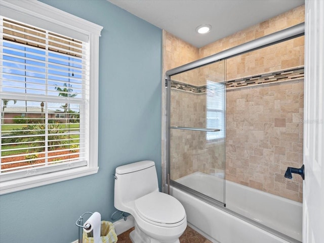 bathroom with shower / bath combination with glass door and toilet