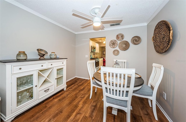 dining space featuring a textured ceiling, ceiling fan, dark hardwood / wood-style flooring, and crown molding