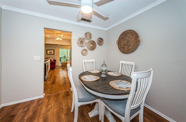 dining room with ceiling fan, a textured ceiling, and dark wood-type flooring