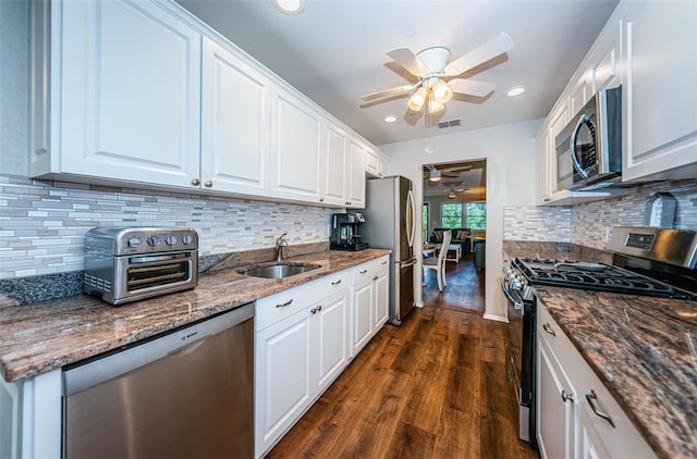 kitchen with backsplash, sink, appliances with stainless steel finishes, dark wood-type flooring, and white cabinetry