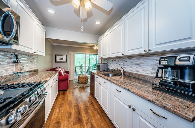 kitchen with backsplash, stainless steel appliances, white cabinetry, and dark hardwood / wood-style flooring