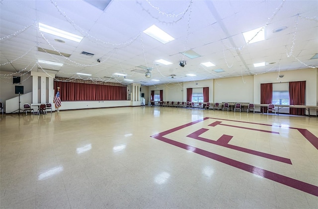 interior space with a drop ceiling and tile patterned floors