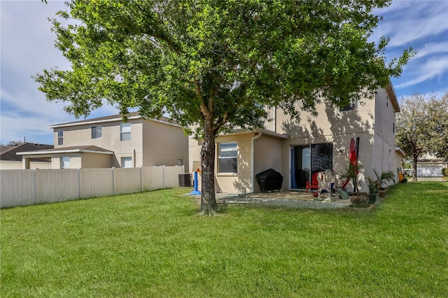 rear view of house with a yard, central AC, and a patio area