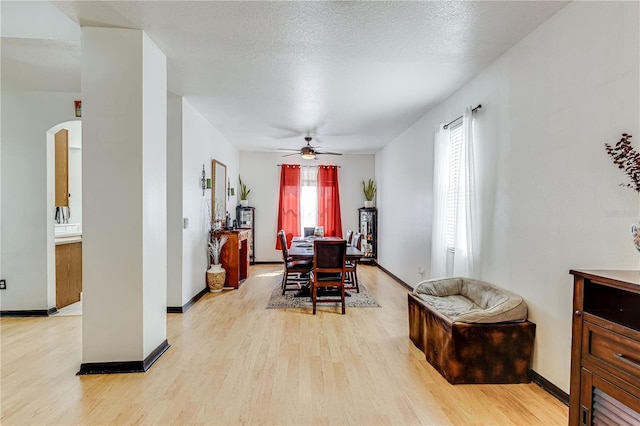 dining room featuring a textured ceiling, ceiling fan, and light hardwood / wood-style flooring