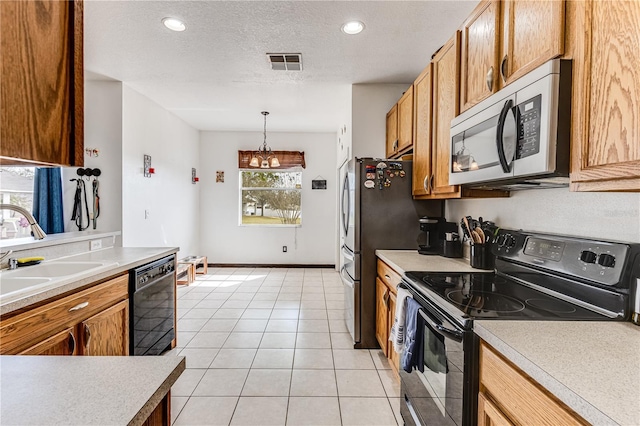 kitchen featuring light tile patterned flooring, sink, a textured ceiling, decorative light fixtures, and black appliances