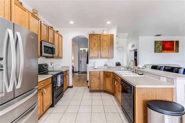 kitchen featuring a kitchen island, black appliances, light tile patterned flooring, and sink