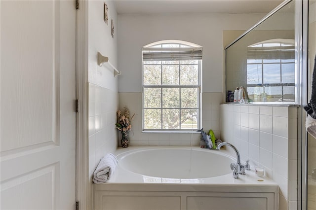 bathroom featuring tile walls and separate shower and tub