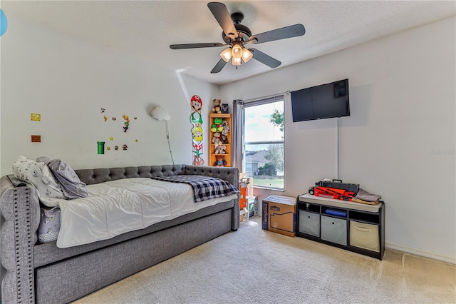 carpeted bedroom featuring a textured ceiling and ceiling fan