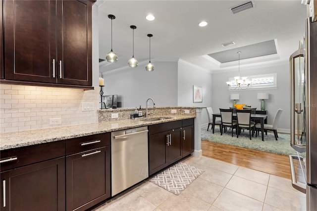 kitchen with appliances with stainless steel finishes, light hardwood / wood-style flooring, backsplash, sink, and light stone counters