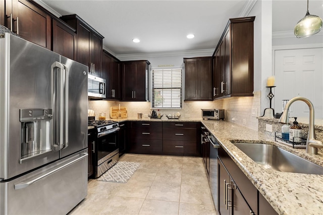 kitchen with backsplash, hanging light fixtures, appliances with stainless steel finishes, light stone counters, and sink