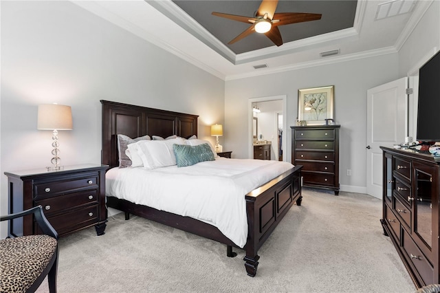 carpeted bedroom with ceiling fan, connected bathroom, ornamental molding, and a tray ceiling