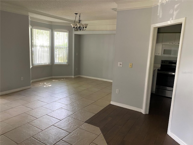 spare room featuring crown molding, hardwood / wood-style floors, a textured ceiling, and a notable chandelier