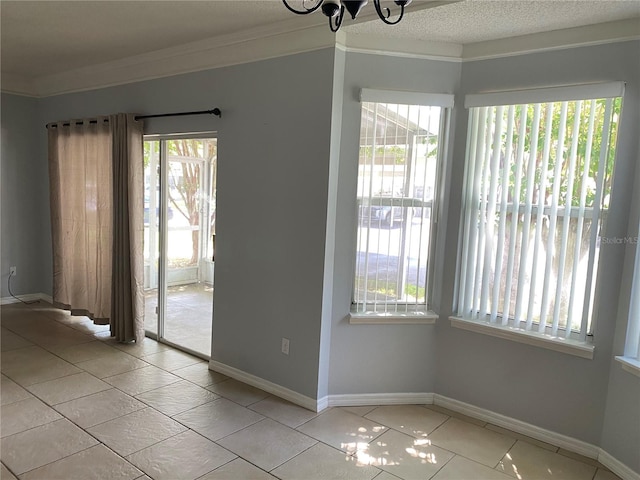 tiled spare room with crown molding, a healthy amount of sunlight, and a textured ceiling