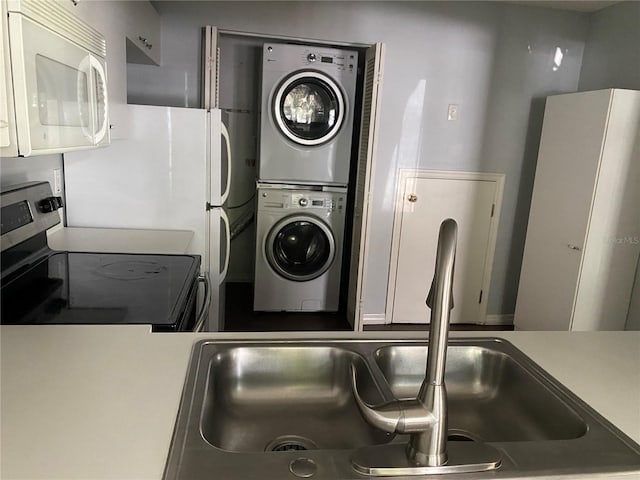 laundry room with sink and stacked washer / dryer