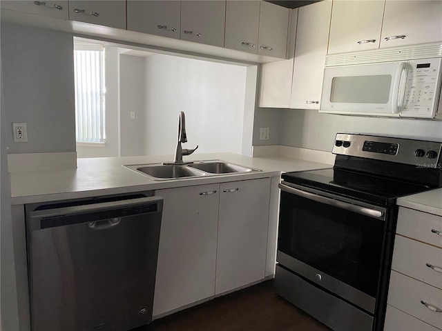 kitchen with sink, stainless steel appliances, kitchen peninsula, and white cabinets