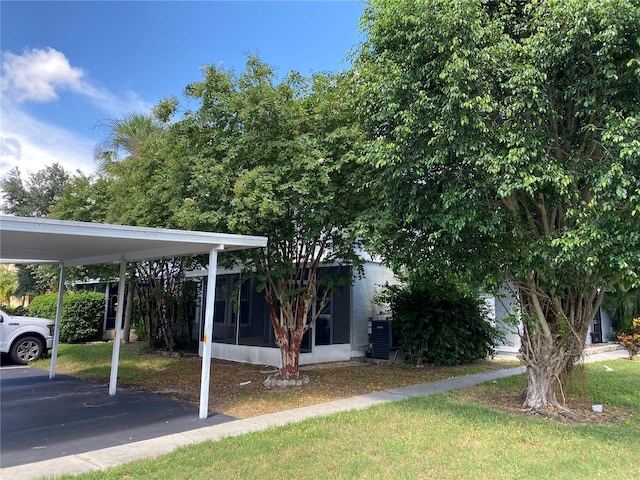 view of yard featuring a carport and a sunroom