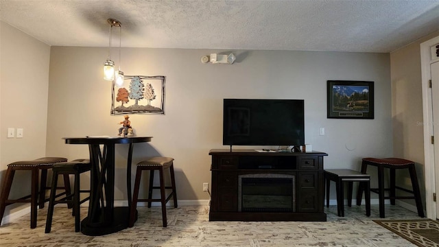 living area with baseboards and a textured ceiling