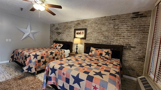 bedroom featuring baseboards, a wall unit AC, wood finished floors, a textured ceiling, and a fireplace