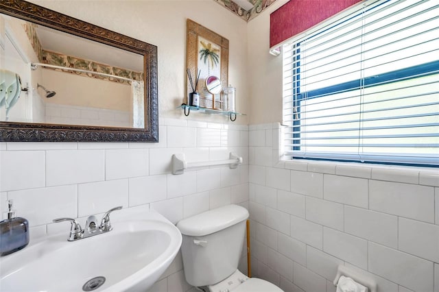 bathroom with tasteful backsplash, tile walls, toilet, and sink