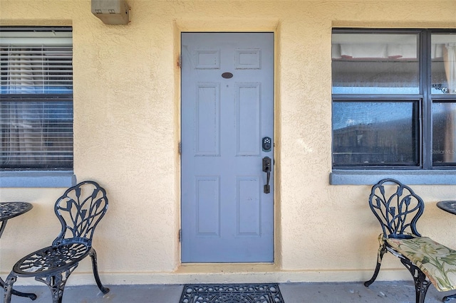 view of exterior entry with stucco siding