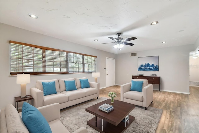 living room featuring ceiling fan and light hardwood / wood-style floors