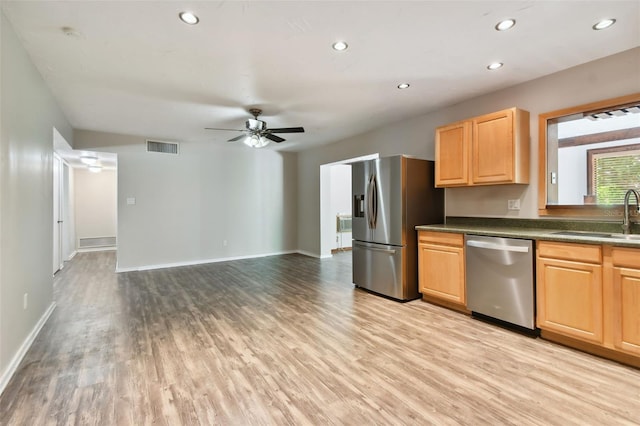 kitchen featuring ceiling fan, appliances with stainless steel finishes, sink, and light hardwood / wood-style flooring