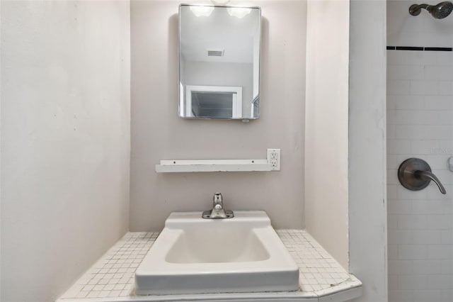 bathroom featuring sink, tile patterned flooring, and a tile shower